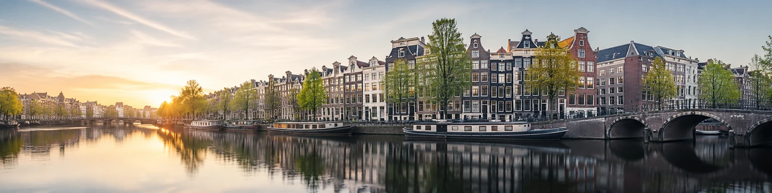 Amsterdam canal city view with historic buildings, bridges, and soft reflections LinkedIn banner