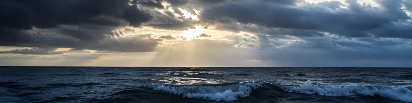 Dramatic storm clouds over sea LinkedIn background banner with ocean waves, dark elegant clouds, and soft light breaking through