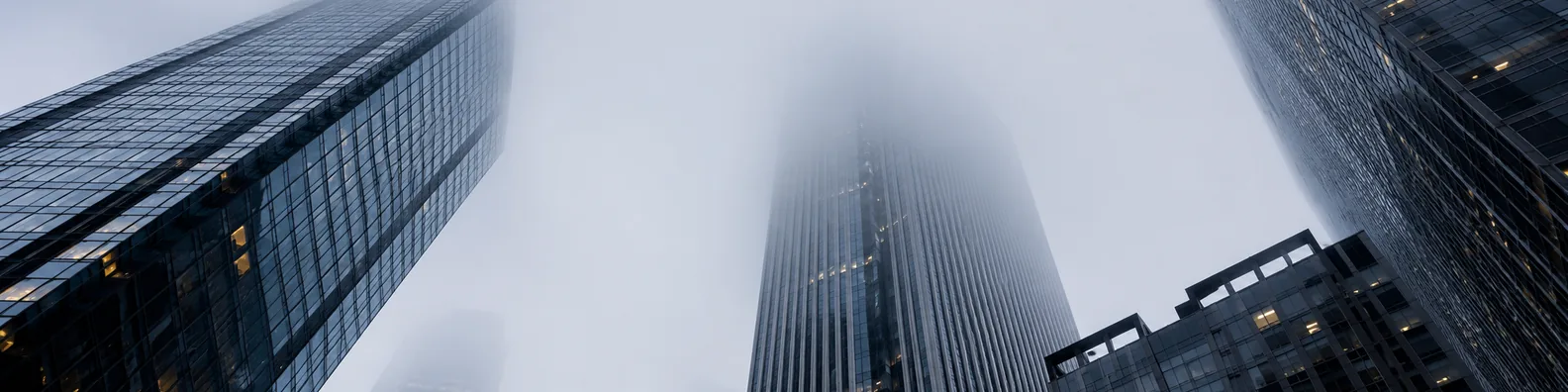 Low angle view of foggy skyscrapers fading into a misty city sky LinkedIn background banner