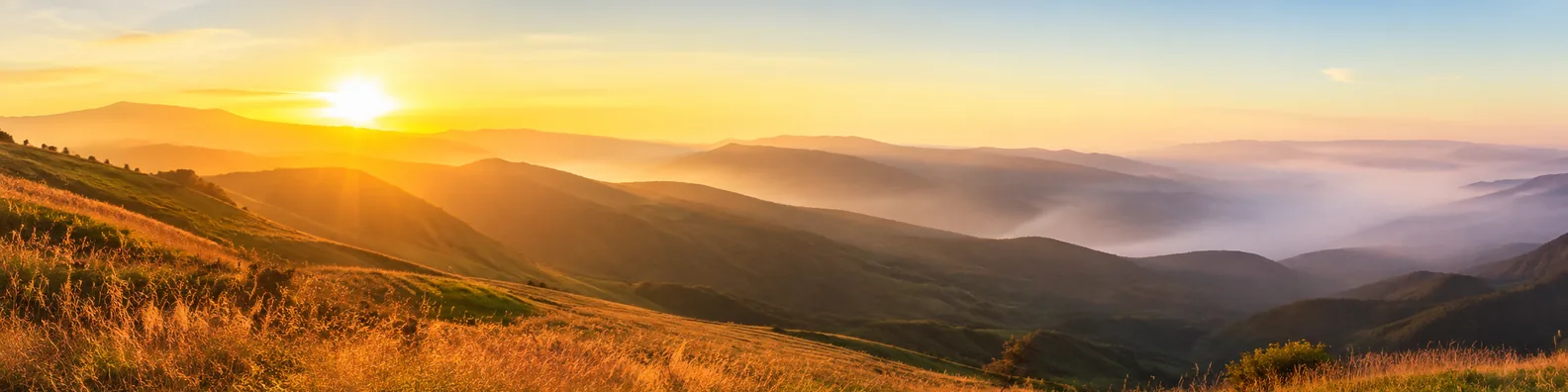 Golden sunrise over hills LinkedIn background banner with rolling hills, morning haze, warm sunlight, and open sky