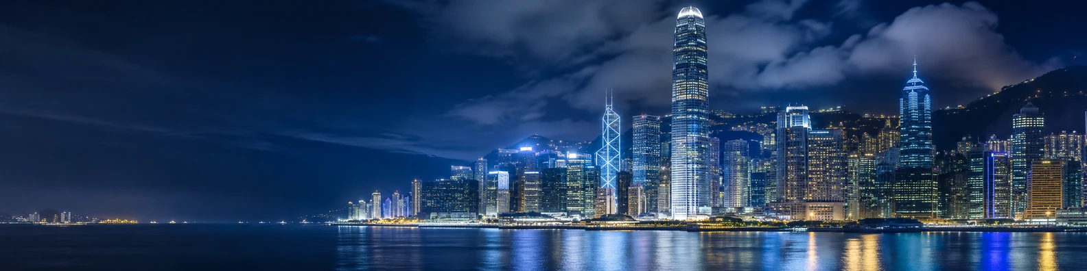 Hong Kong skyline lights at night with harbor reflections and dense high-rise buildings LinkedIn banner