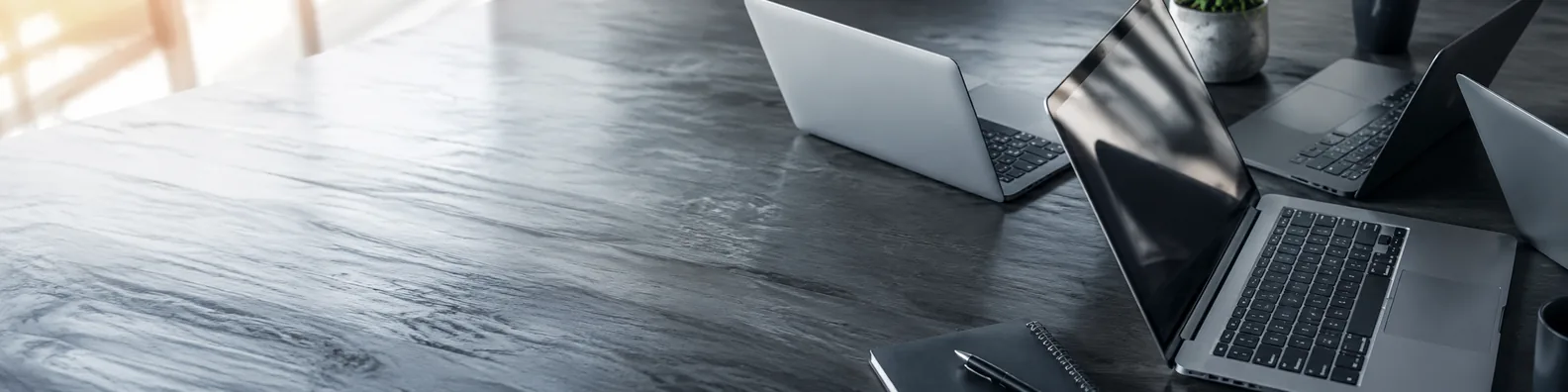 Overlapping laptops on table technology LinkedIn background banner