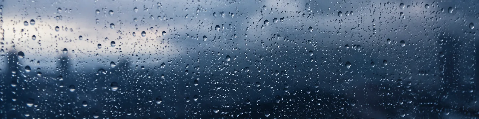 Clear raindrops on glass lens with moody blue grey blurred background LinkedIn banner