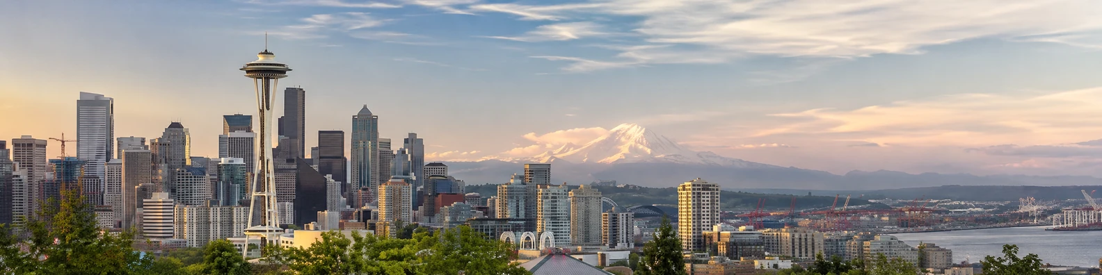 Seattle skyline with mountains in the distance and soft golden light LinkedIn background banner
