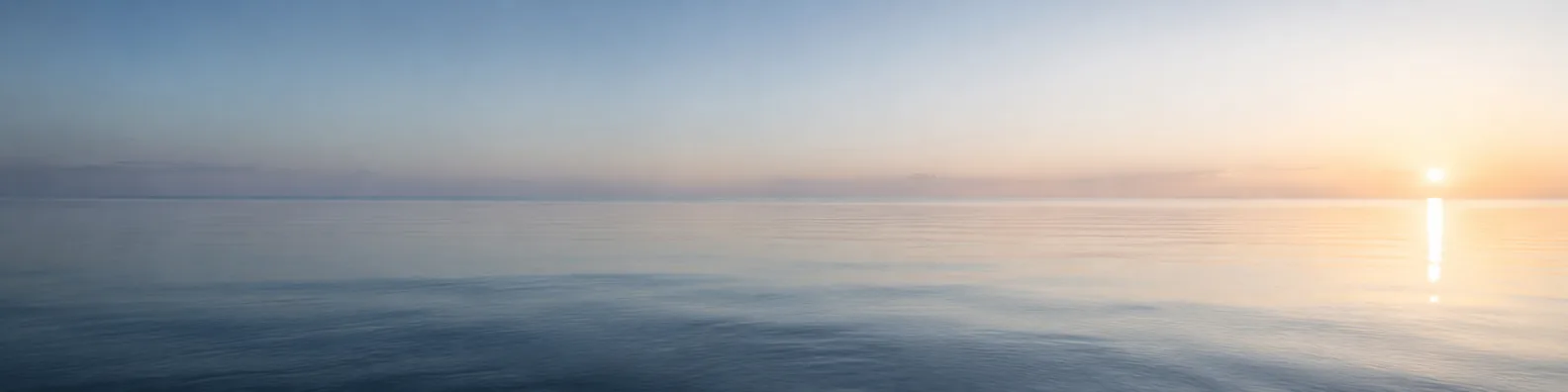 Minimal calm sea horizon with soft sunrise light LinkedIn background banner
