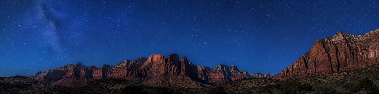 Blue starry sky over red desert mountain silhouettes LinkedIn background banner
