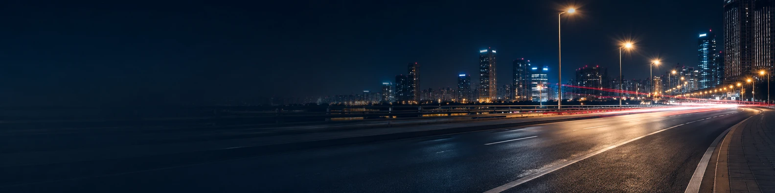 Urban night road background with glowing streetlights and soft traffic light trails LinkedIn banner