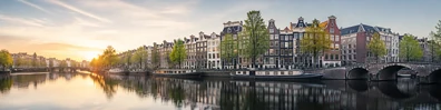 Amsterdam canal city view with historic buildings, bridges, and soft reflections LinkedIn banner