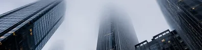 Low angle view of foggy skyscrapers fading into a misty city sky LinkedIn background banner