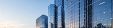Glass office towers with reflective windows and soft sunset light LinkedIn background banner