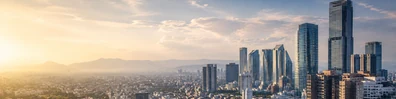Mexico City skyline view with modern high-rise buildings and warm golden haze LinkedIn banner