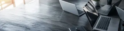 Overlapping laptops on table technology LinkedIn background banner