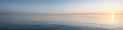 Minimal calm sea horizon with soft sunrise light LinkedIn background banner