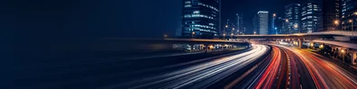 Urban highway light trails with city buildings, overpasses, and night road motion LinkedIn banner